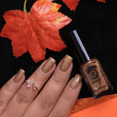 Manicure featuring crushed foil nail polish in copper gold .